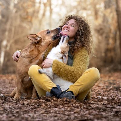 Cani leccano la padrona tutti seduti a terra nel bosco